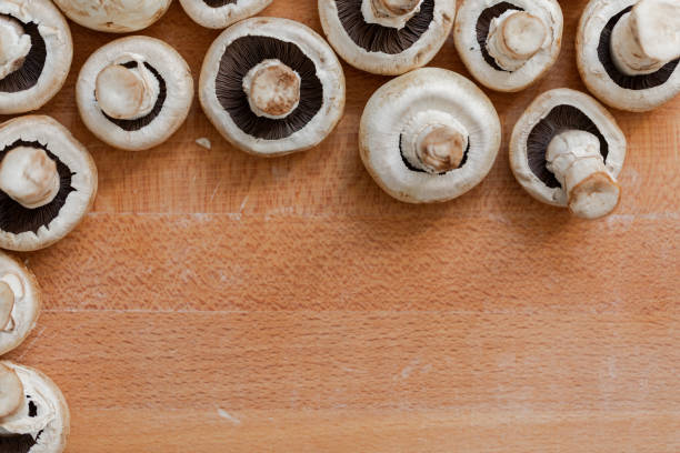 White mushrooms background on wood board, close-up stock photo