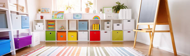White nursery room with shelves and colourful boxes. stock photo