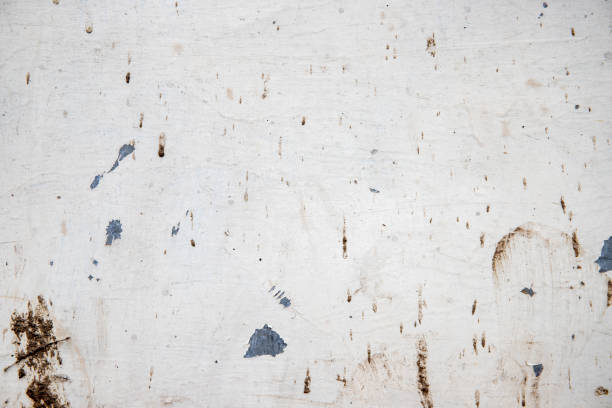 White painted wall with grit and stains, closeup photo texture. Corrosion and distressed marks on metallic surface stock photo