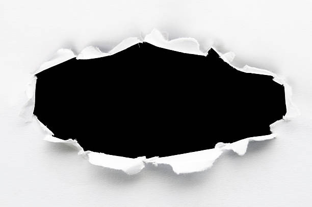 White paper ripped to create a black hole close-up of a paper hole. hole stock pictures, royalty-free photos & images