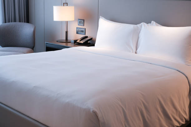 almohadas blancas y cama en la habitación del hotel. acogedora cama blanca por la mañana. - camas fotografías e imágenes de stock