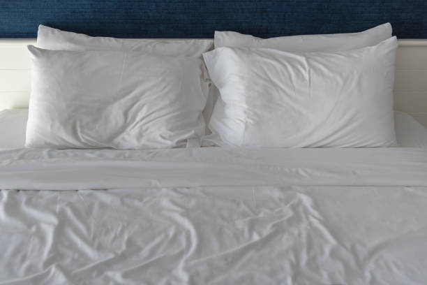 blanco almohadas de la cama - plastic bed covers fotografías e imágenes de stock