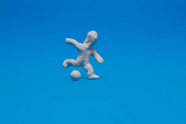 A white plasticine doll practicing soccer stock photo