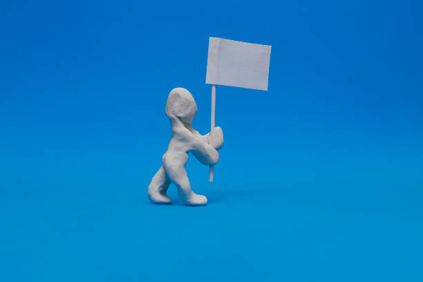 A white plasticine dummy carrying a white flag stock photo