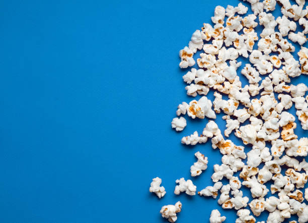 white popcorn on a blue back stock photo