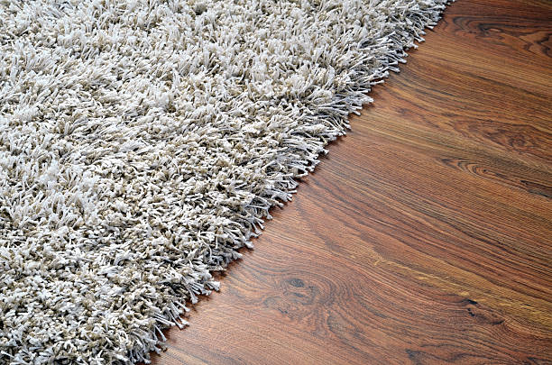 White shaggy carpet on brown wooden floor stock photo