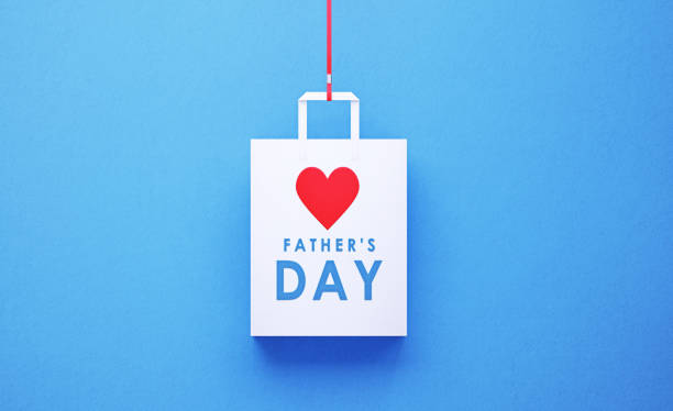 White Shopping Bag with Father's Day Message on Blue Background White shopping bag with heart shape and Mother's day message on blue background. Horizontal composition with copy space, Great use for Father's day related gift concepts. fathers day stock pictures, royalty-free photos & images