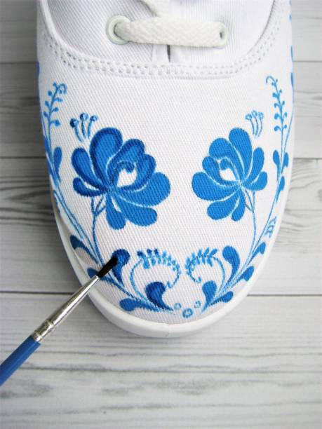 White sneakers hand painted with blue paint stock photo