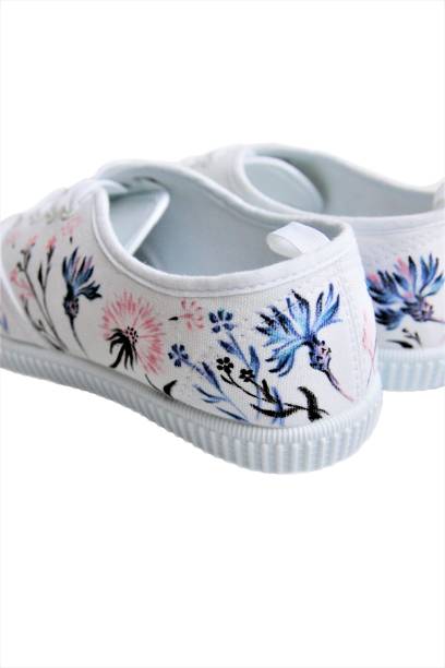 white sneakers with hand-painted wild flowers rear view stock photo
