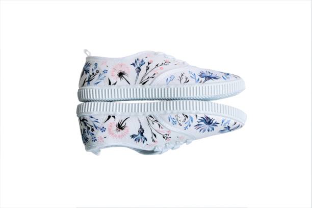 white sneakers with hand-painted wild flowers side view stock photo