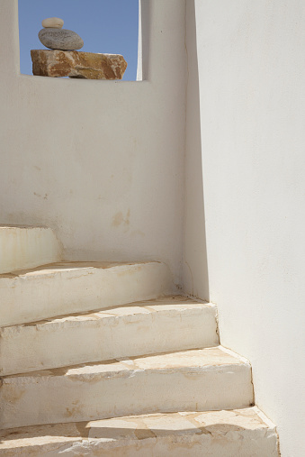 White Staircase Leading up by a Window with Rock Arrangement and in Paros, Greece