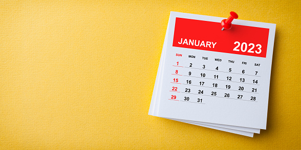 White Sticky Note With 2023 January Calendar And Red Push Pin On Blue Background