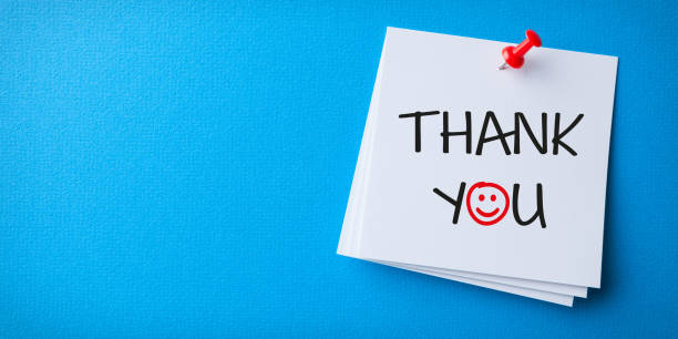White Sticky Note With Thank You And Red Push Pin On Blue Background stock photo