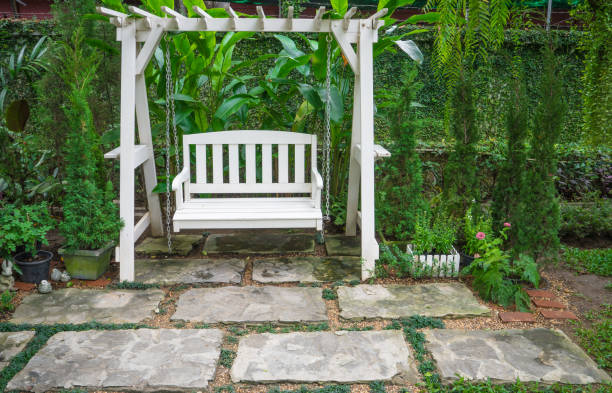 White Swing In A Garden Concept Of Relaxation Stock Photo