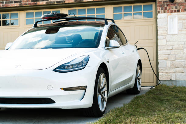 White Tesla Model 3 Charging at Home stock photo