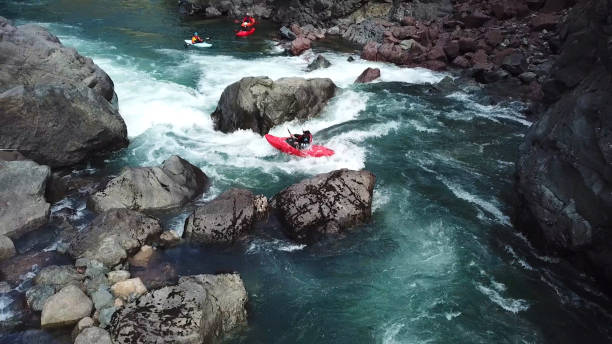 White water kayaker paddles down river to meet friends View from above to rapids below rapids river stock pictures, royalty-free photos & images