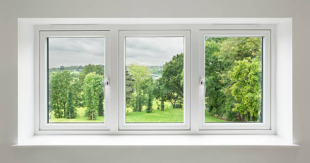 white windows with garden view a set of three windows in a white frame surrounded by a light grey wall with views over a lovely countryside garden. with mature trees. window sill photos stock pictures, royalty-free photos & images