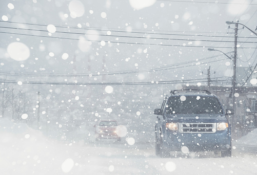 Motorists navigate a city street in white out conditions.