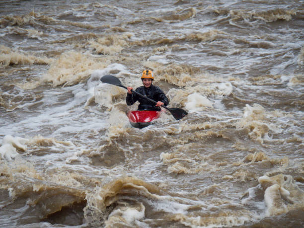 Whitewater Kayakers in flooded Yarra River Dights Falls weir after wild storms stock photo