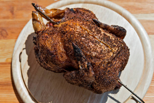 whole chicken baked in the smoker on chopping board picture - The Tasty Hub