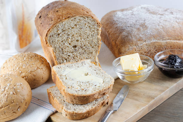 Whole grain bread and buns with butter and jelly stock photo