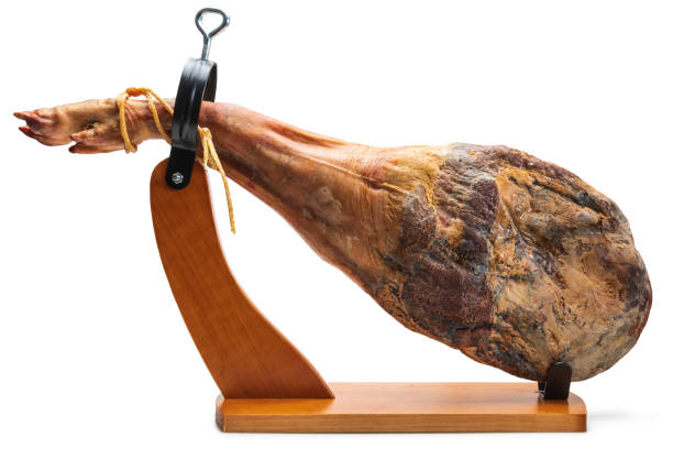 Whole leg of Spanish Iberian serrano ham in wooden support (jamoneror). Isolated on white background. Whole leg of Spanish Iberian serrano ham in wooden support (jamoneror). Isolated on white background. animal leg stock pictures, royalty-free photos & images