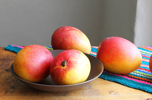 Whole Mangos on a Table stock photo