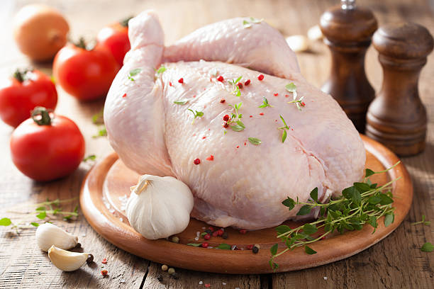 whole raw chicken with rose pepper and thyme stock photo