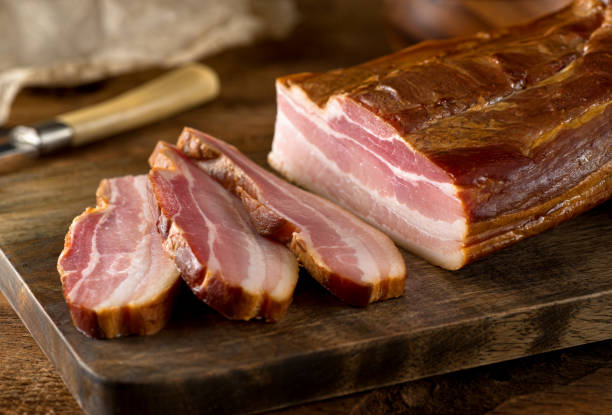 Whole Smoked Slab Bacon Delicious artisanal whole smoked slab bacon on a cutting block. bacon photos stock pictures, royalty-free photos & images