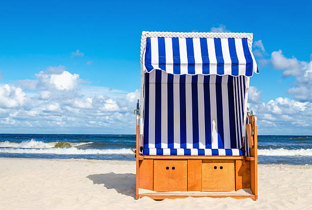 Wicker chair on sandy Kolobrzeg beach, Baltic Sea, Poland stock photo