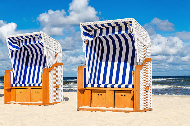 Wicker chairs on sandy Kolobrzeg beach by Baltic Sea, Poland stock photo