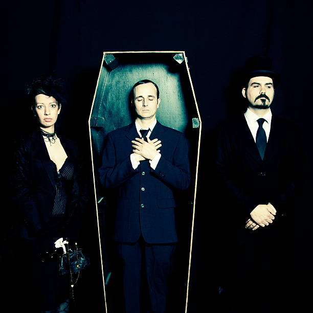 Widow, undertaker and man in coffin stock photo