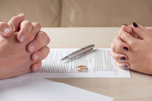 wife and husband signing divorce documents or premarital agreement hands of wife and husband signing divorce documents or premarital agreement divorce stock pictures, royalty-free photos & images