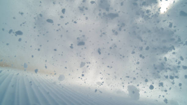 POV: Wild avalanche rushes down the groomed ski slopes in the beautiful Alps. stock photo