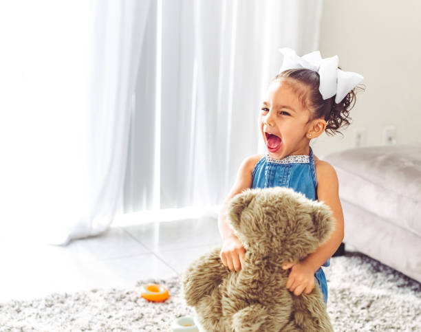 Wild, screaming little girl toddler playing at home stock photo