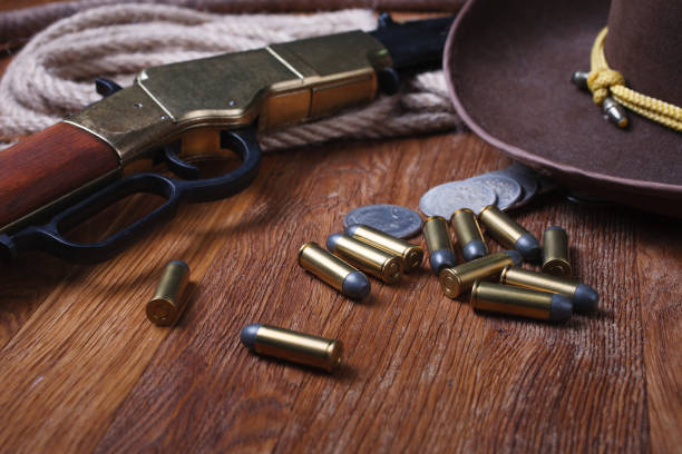 Wild west rifle, ammunition and sheriff badge Wild west rifle, ammunition and sheriff badge on wooden table texas shooting stock pictures, royalty-free photos & images