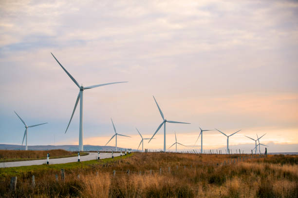 Wind Energy In Scotland A beautiful sunset in the Scottish highlands with renewable energy wind turbines far into the horizon cirrostratus stock pictures, royalty-free photos & images