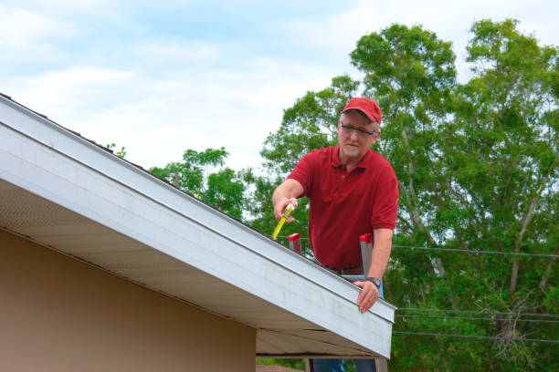 Wind mitigation inspection inspector on a ladder doing inspection on new roof to generate a risk rating stock photo