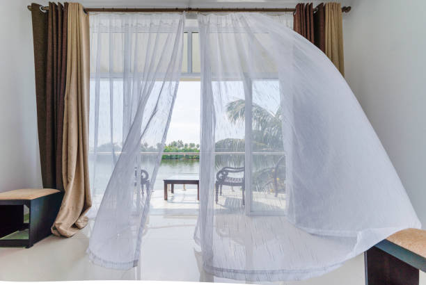 Viento moviendo cortinas en la ventana abierta del balcón con la vista panorámica de un río desde la moderna habitación de hotel vacía. Habitación de hotel moderna en Sri Lanka. cortina fotos e imágenes de stock