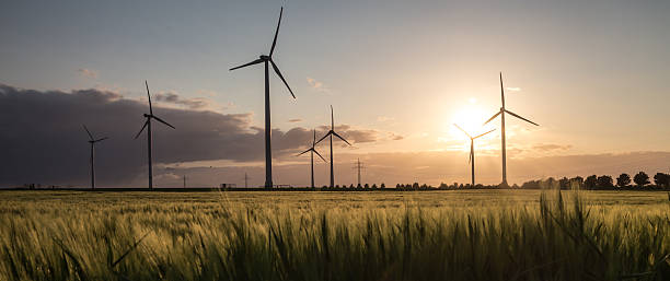 windkraftanlage bauernhof sonnenuntergang - windrad stock-fotos und bilder