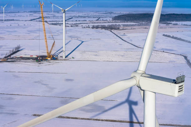 windkraftanlage im winter mit schnee und krahn-luftbild und nahansicht - tim siegert stock-fotos und bilder