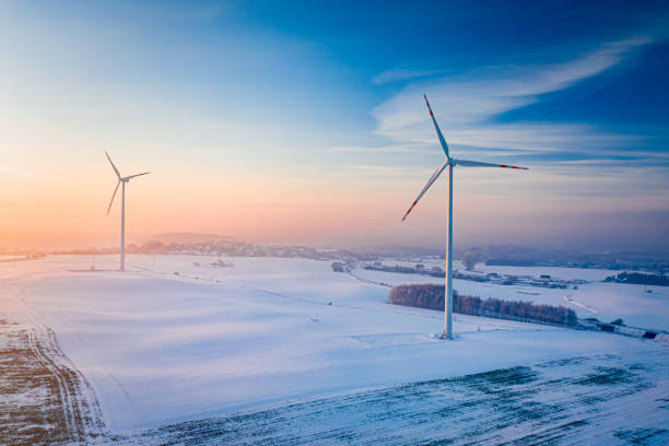 Wind turbine on snowy field. Aerial view of winter nature stock photo