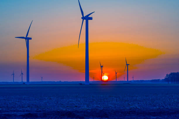 Wind turbines for renewable energy in an agricultural field in bright blue orange sunlight at sunrise in spring Wind turbines for renewable energy in an agricultural field in bright blue orange sunlight at sunrise in spring, Almere, Flevoland, The Netherlands, April 17, 2021 flevoland stock pictures, royalty-free photos & images