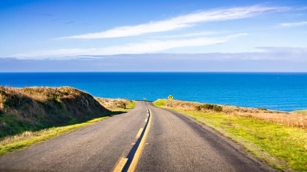 Winding road on the Pacific Ocean coastline on a clear sunny day, Point Reyes National Seashore, California stock photo