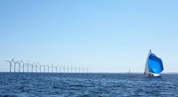 Windmills and a sailboat stock photo