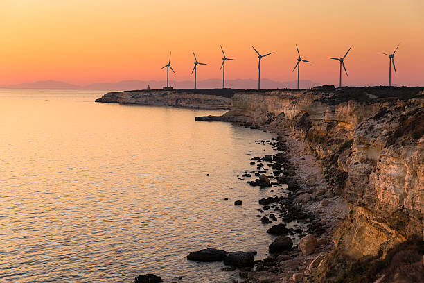 Windmills on the edge of the cliff near Polente lighthouse stock photo