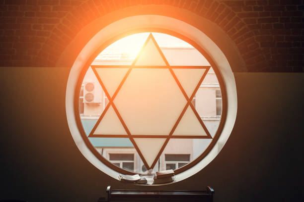 окно в синагоге в виде звезды давида, шестиконечная звезда с солнечным светом, еврейский символ - synagogue стоковые фото и изображения