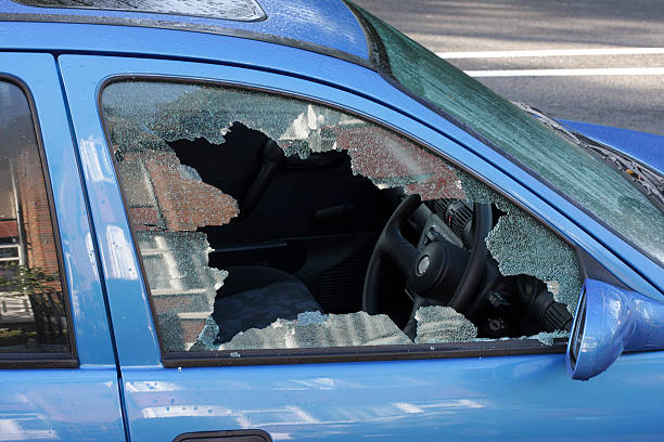 Window smashed by car thief street scene A jagged black hole with cracked and crazed glass reveals the workings of a thief in the night, during the morning after. One more car crime on the streets of London. vandalism stock pictures, royalty-free photos & images