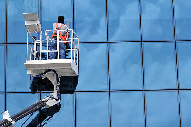 Window washer Window cleaner working on a glass facade in a gondola building cleaning stock pictures, royalty-free photos & images