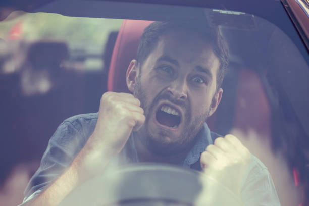 Windshield view of an angry driver man. Negative human emotions face expression Windshield view of an angry driver man. Negative human emotions face expression worried man funny stock pictures, royalty-free photos & images